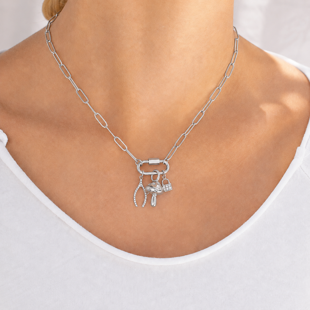 Silver necklace with charms on a person wearing a white top