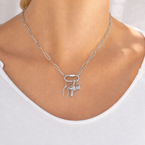 Silver necklace with charms on a person wearing a white top