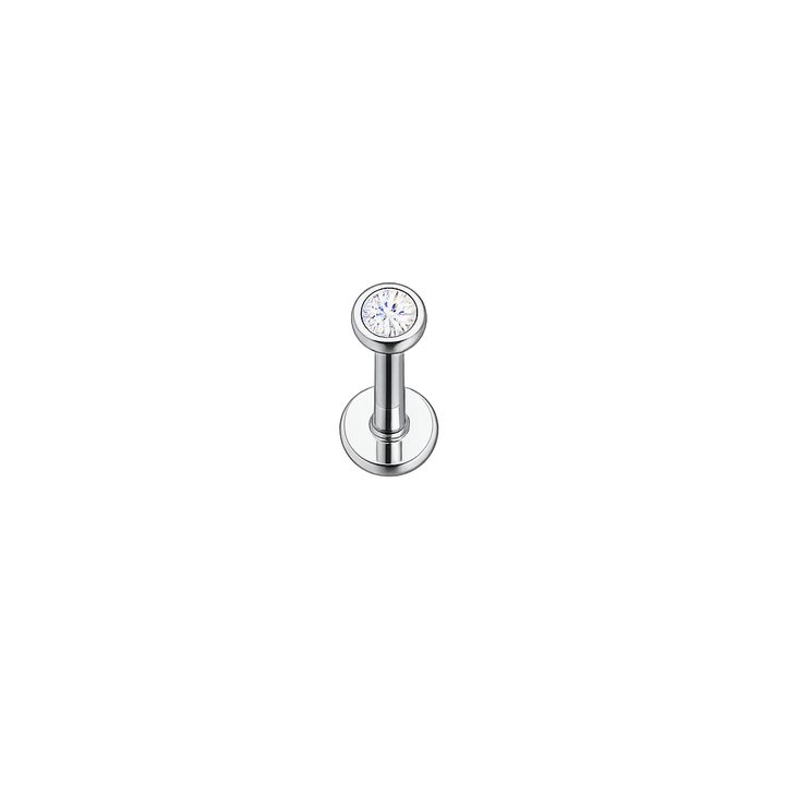 Silver lip ring with a clear gemstone on a white background