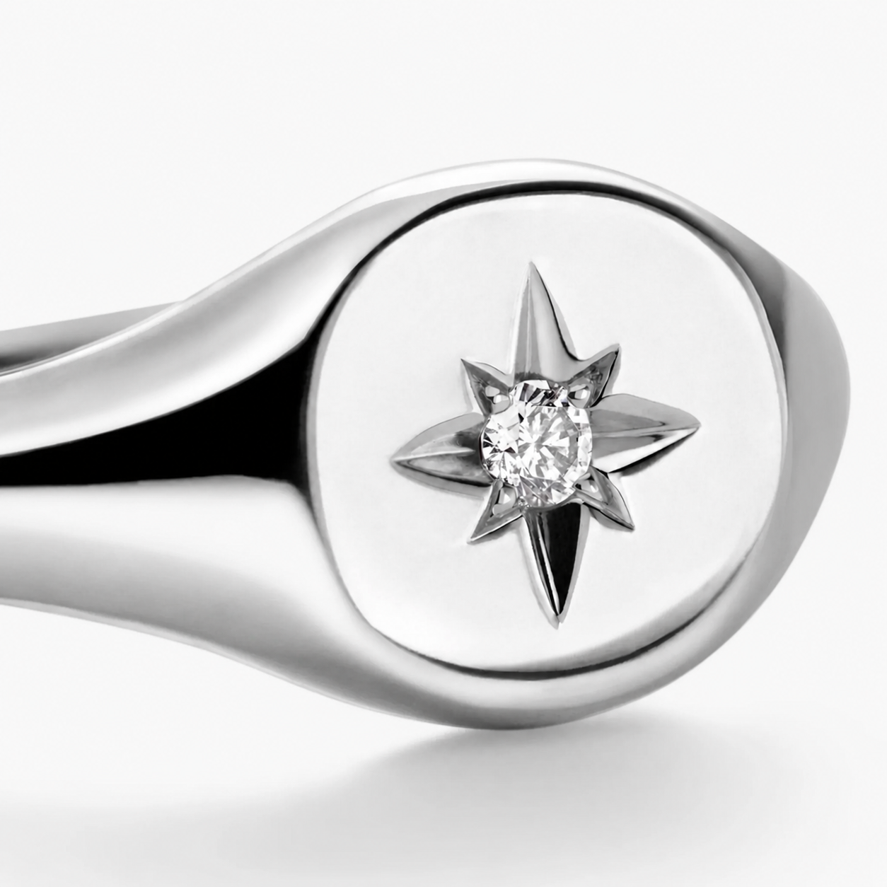 Silver ring with a diamond set in a star-shaped prong on a white background