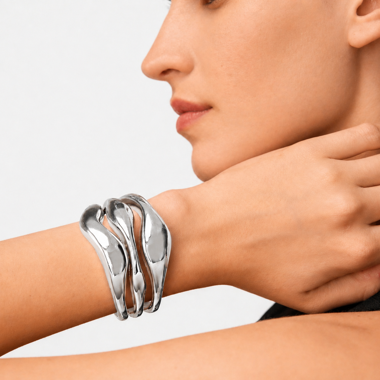 Silver bracelet on a wrist with a neutral background