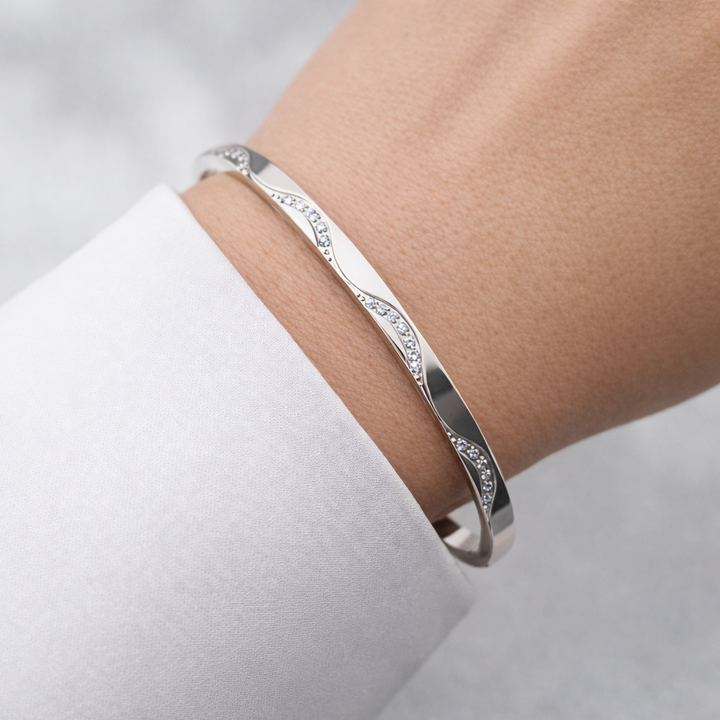 Silver bracelet on a person's wrist with a light background