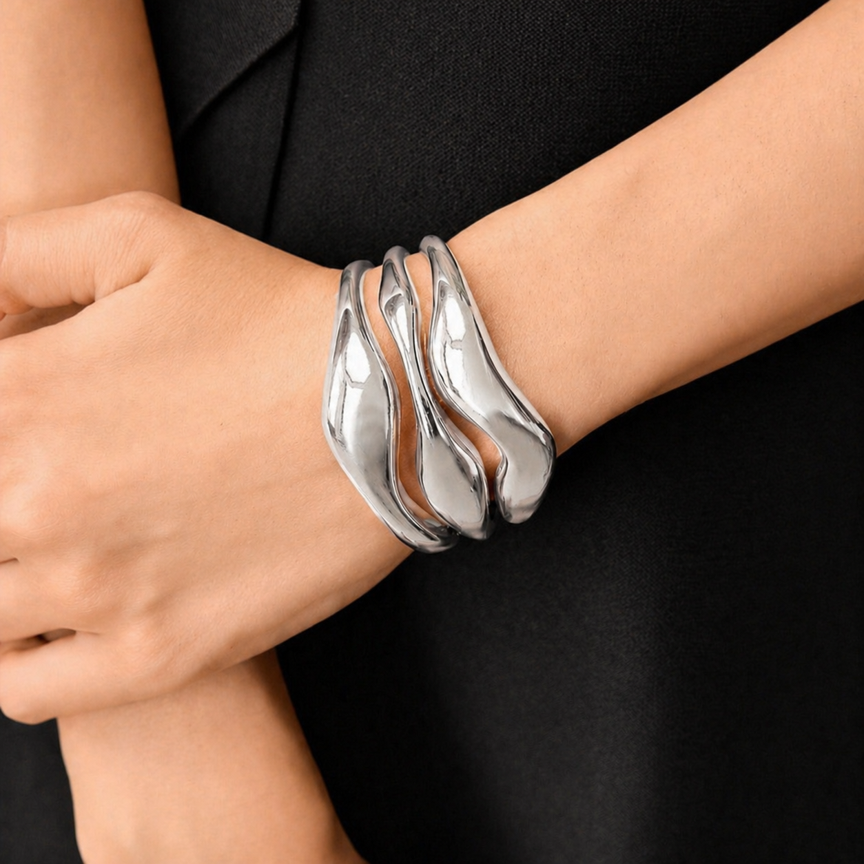 Silver bracelet on a wrist against a black background