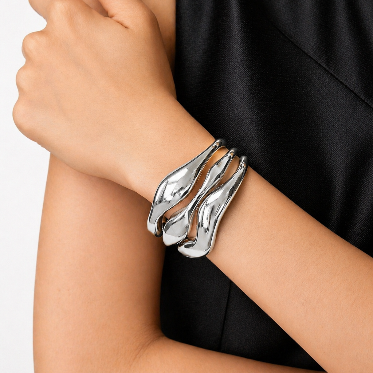 Silver bracelet on a person's wrist with a plain background