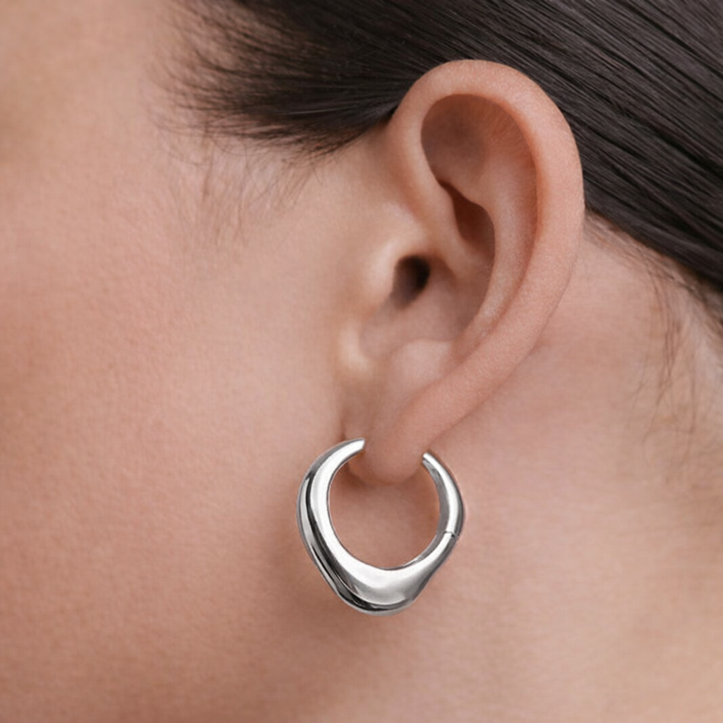 Silver hoop earring worn by a person