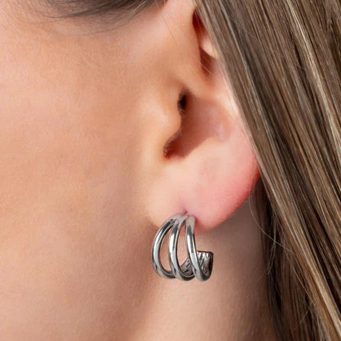 Close-up of a person wearing a silver hoop earring.