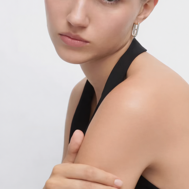 Woman wearing a black sleeveless top with a plain background
