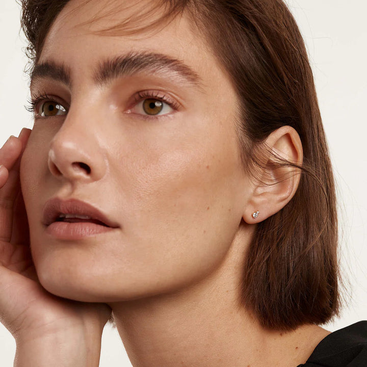 Close-up of a woman with a neutral expression on a plain background