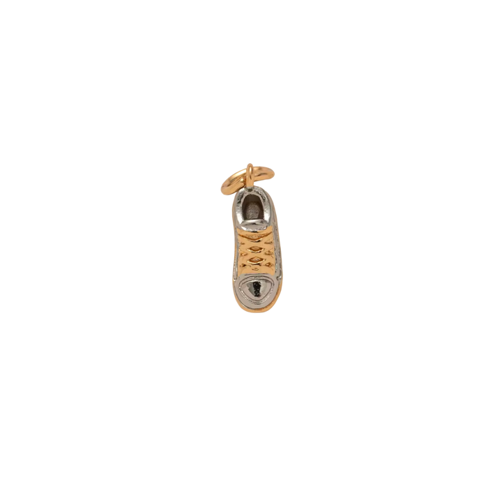 Gold and silver shoe charm on a white background