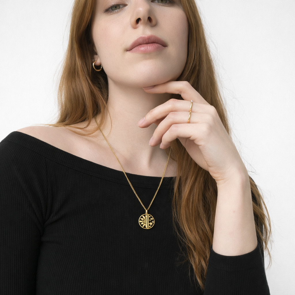 Woman wearing a gold necklace with a black top on a white background
