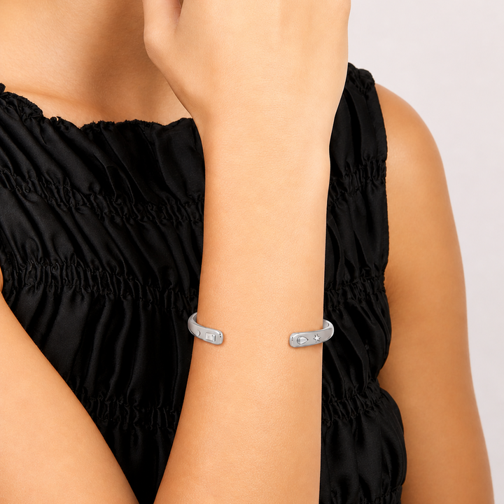Woman wearing a silver bracelet on a plain background