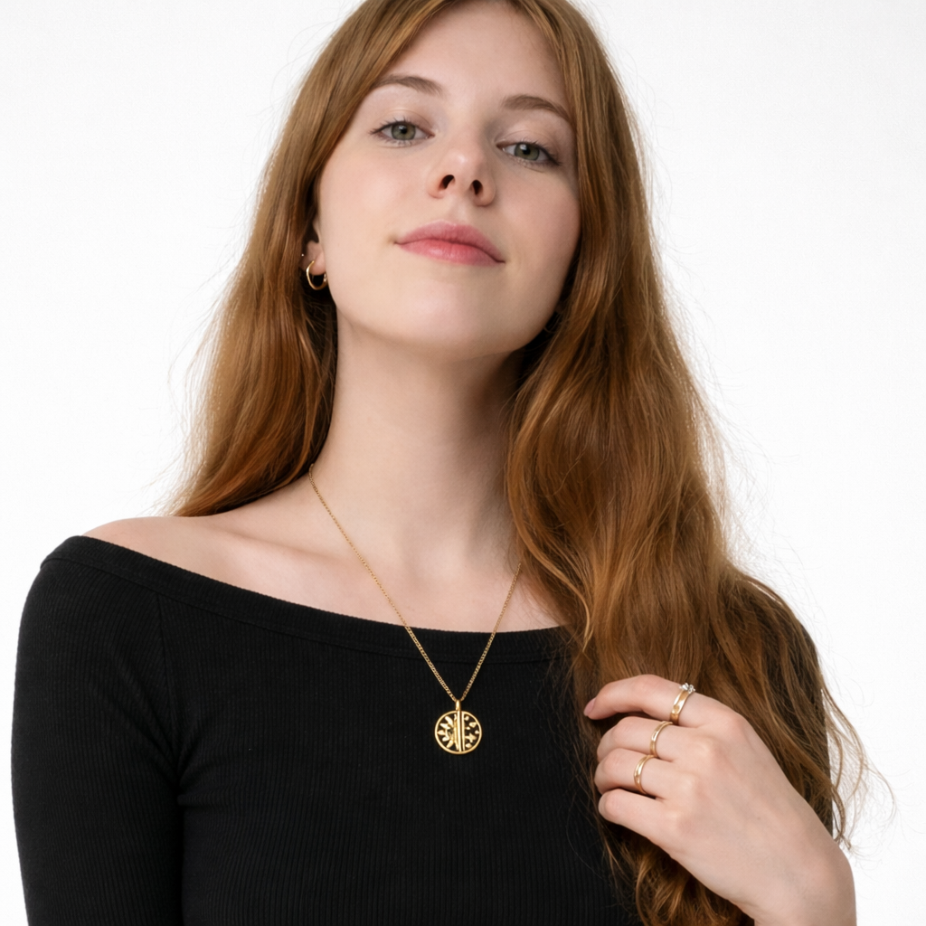 Woman wearing a gold necklace with a black top on a white background