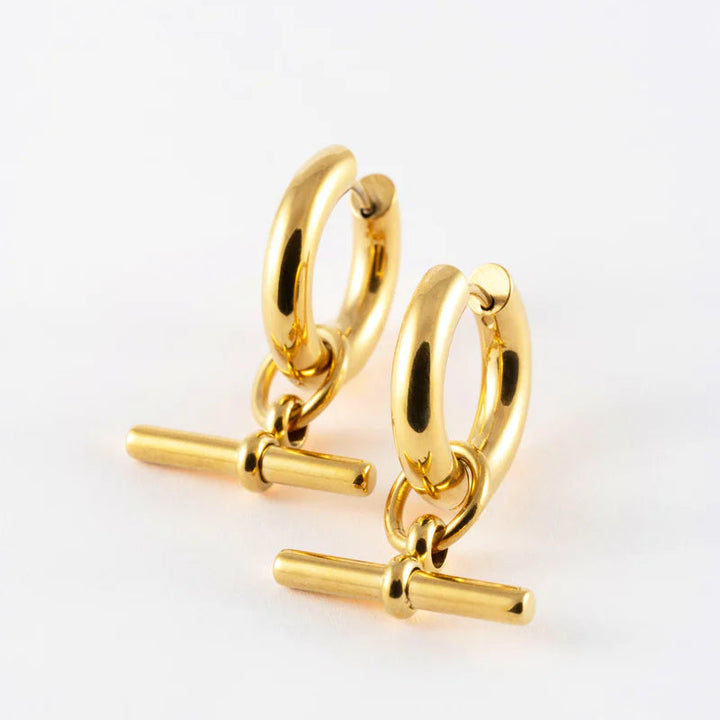 Gold hoop earrings with bar accessories on a white background