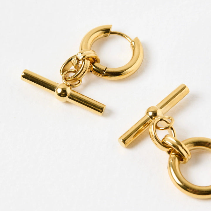 Pair of gold hoop earrings with a bar and ring design on a white background