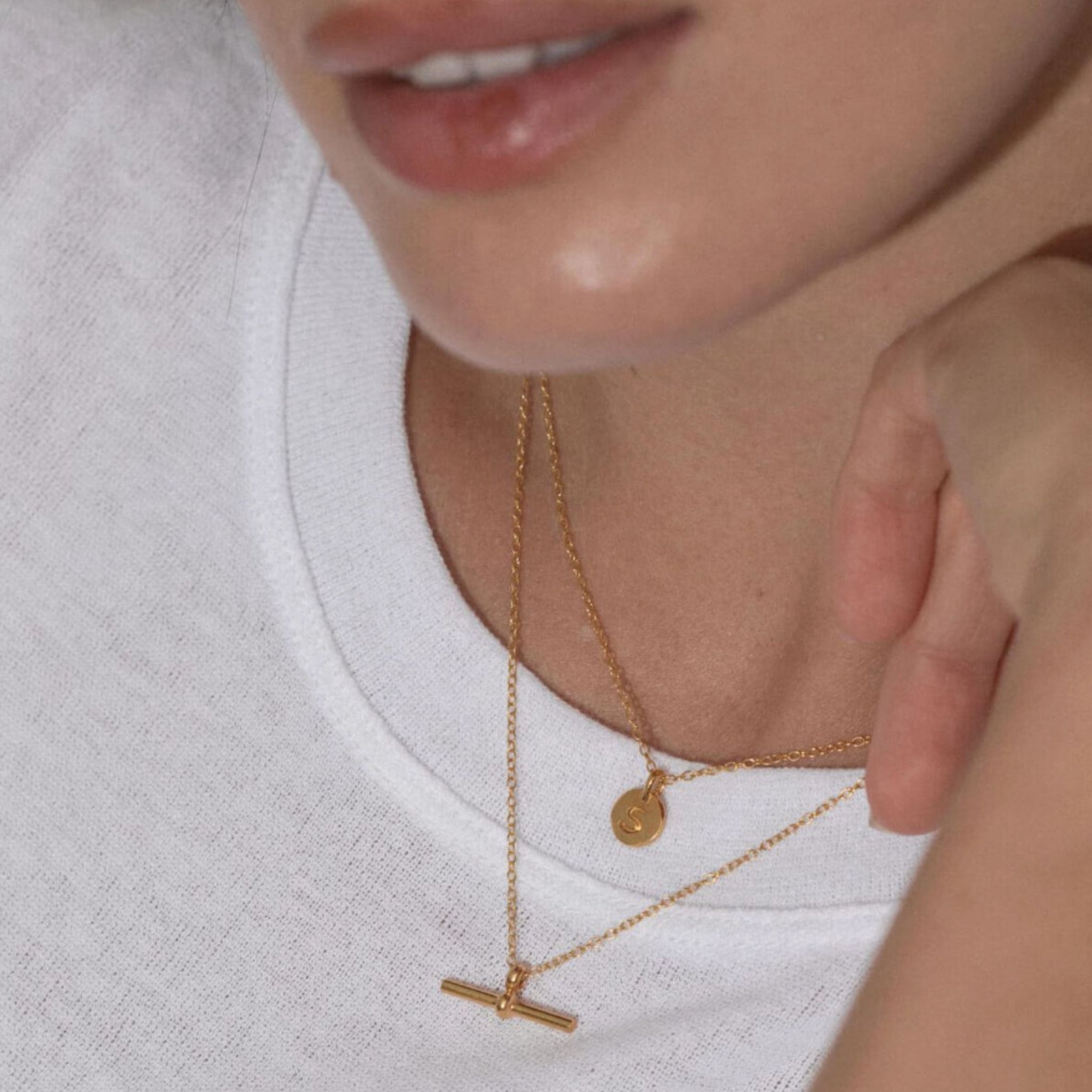 Close-up of a person wearing gold necklaces with a blurred background