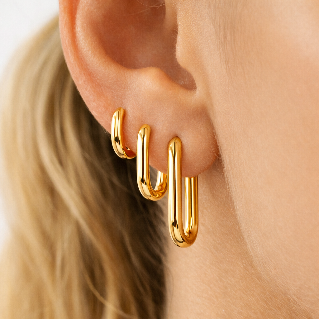 Gold hoop earrings worn by a person with blonde hair.