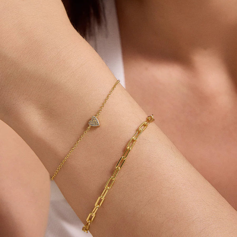 Gold bracelet on a person's wrist with a blurred background