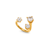 A gold ring featuring three round-cut clear gemstones in a split, open band design, photographed on a clean white background.