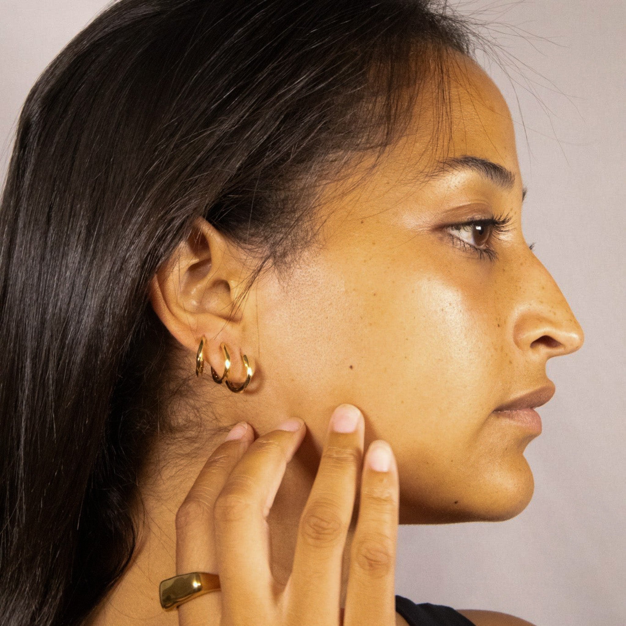 Gold Twisted Mini Hoops worn on ear