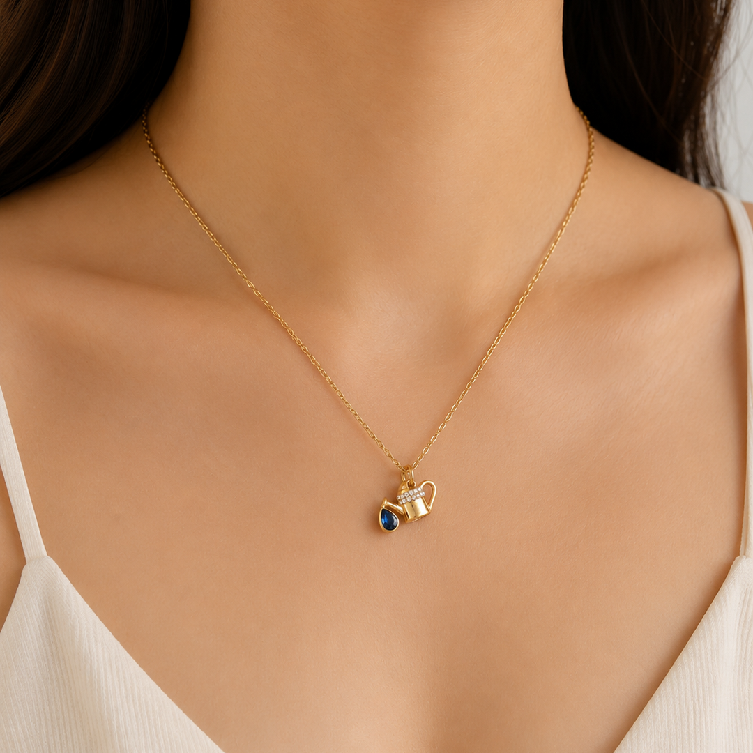 Gold necklace with a heart-shaped pendant on a model wearing a white top.