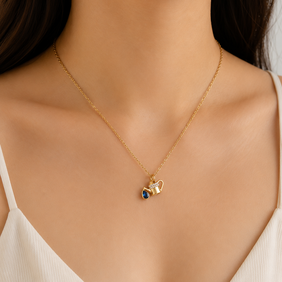 Gold necklace with a heart-shaped pendant on a model wearing a white top.