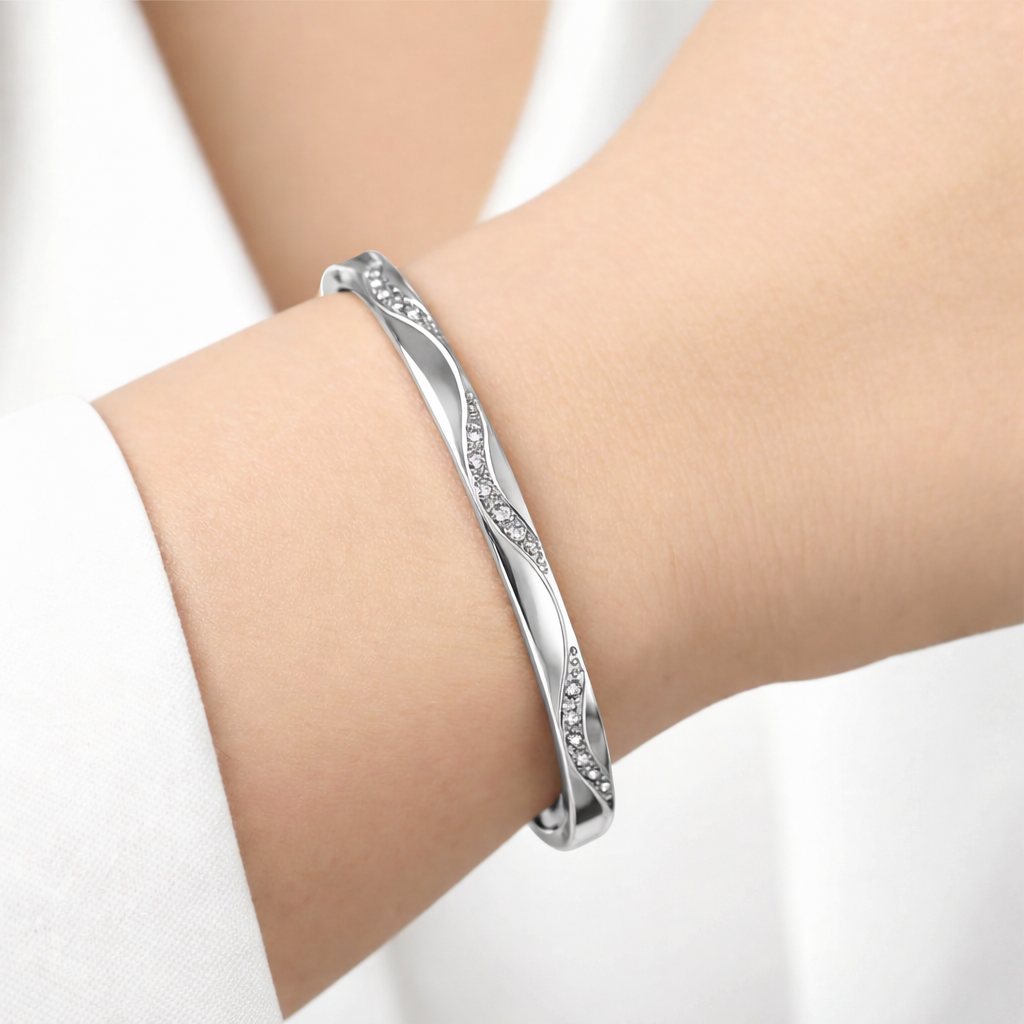 Silver bracelet on a person's wrist against a white background