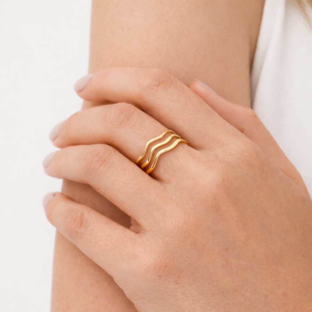 Gold ring on a hand against a neutral background