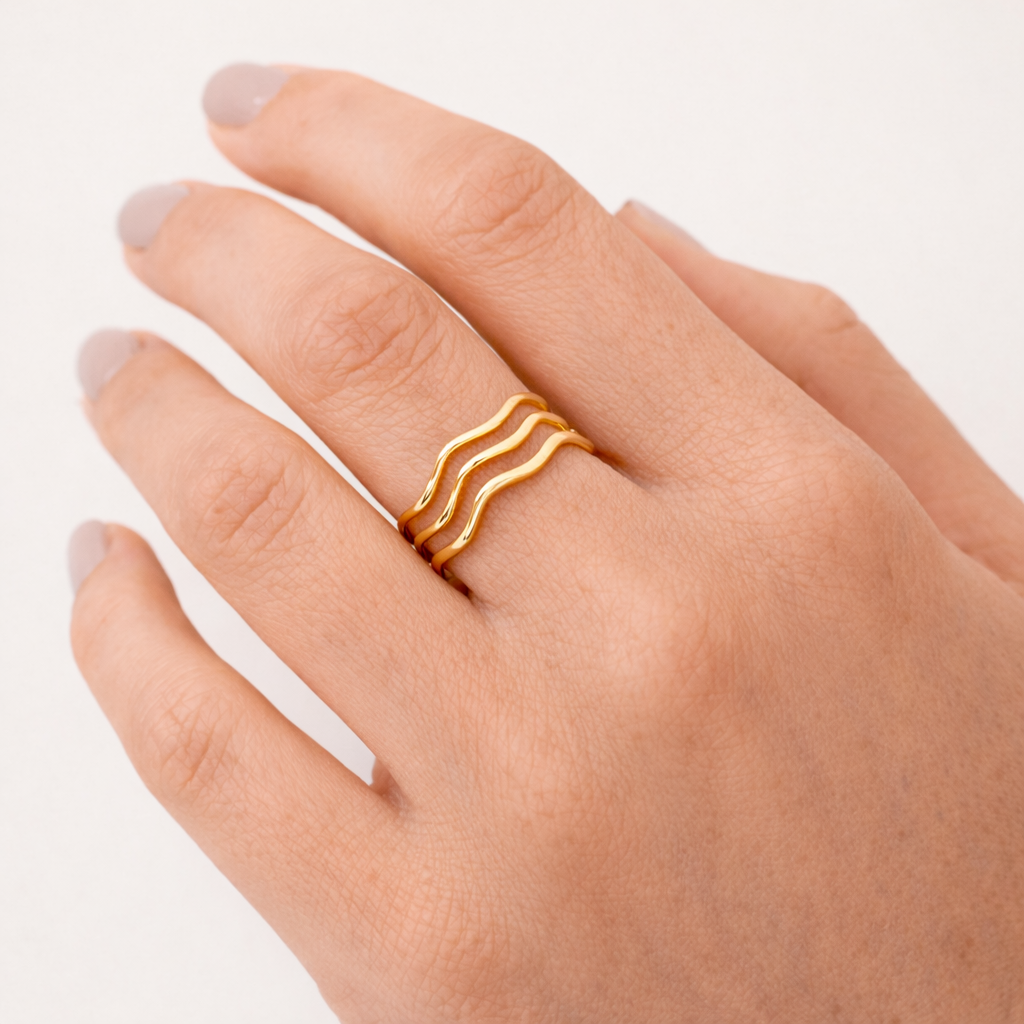 Gold ring on a hand against a light background