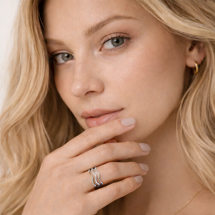 Close-up of a woman wearing a silver ring with a neutral background