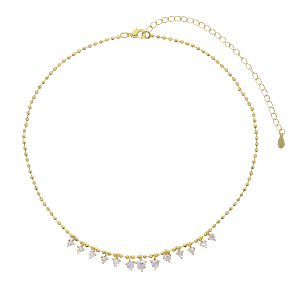 A gold beaded choker necklace with a row of small clear heart-shaped crystals hanging from the front, shown on a plain white background.