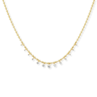 A delicate gold chain necklace featuring a curved row of small clear gemstones, photographed against a solid white background.